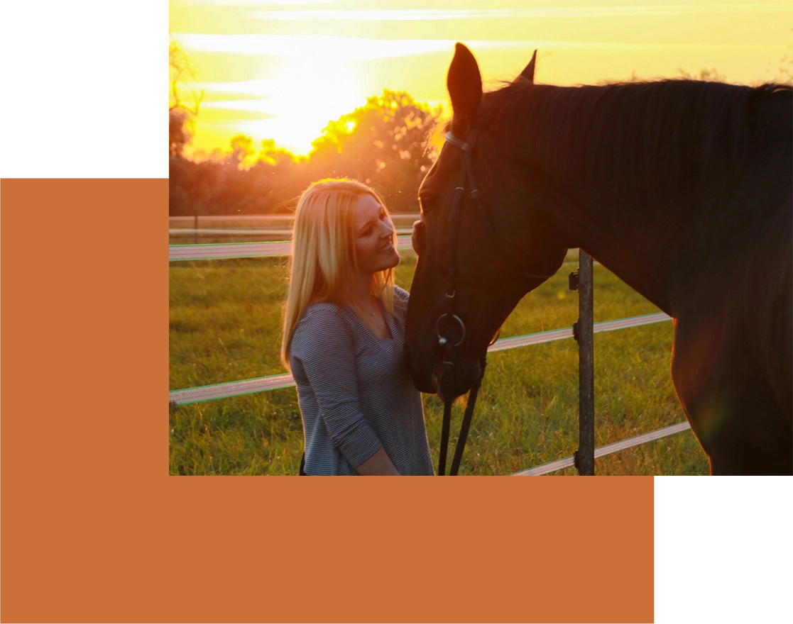 A woman standing next to a horse in an enclosed area.